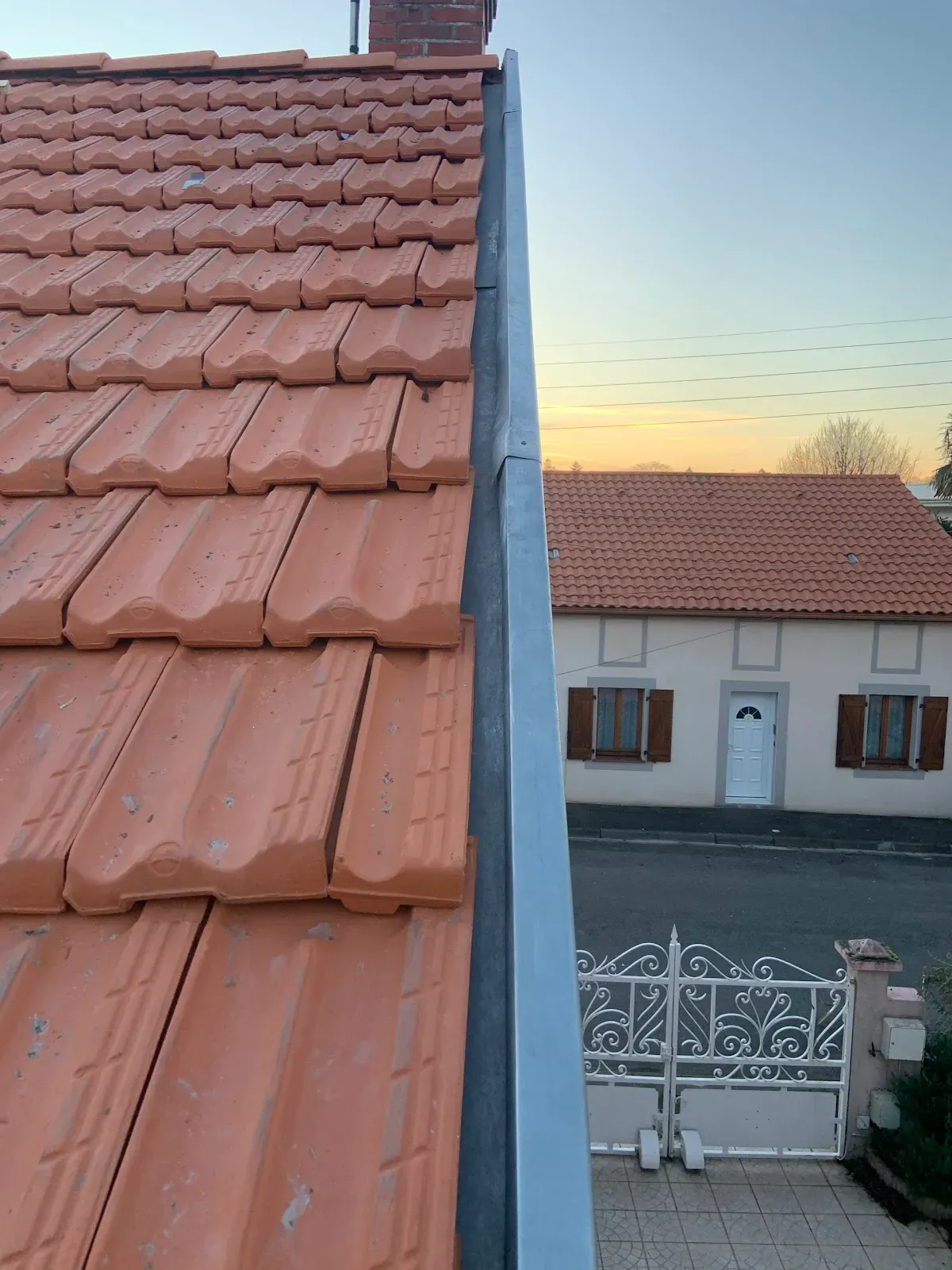 Détail de tuiles propres et d’une zinguerie le long d’une rive de toit